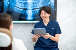 患者が歯科医師に歯の痛みを相談する様子